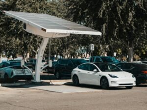 Mobil listrik sedang mengisi daya di stasiun pengisian energi terbarukan.